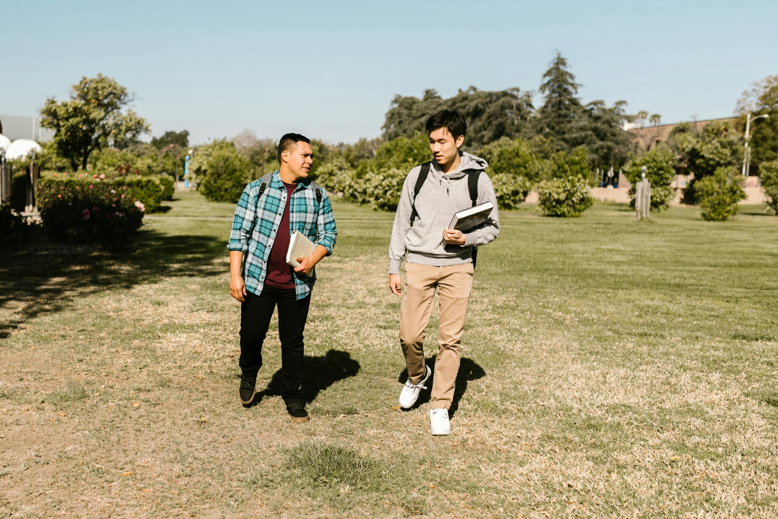 two guys walking on college campus and talking while having a great time